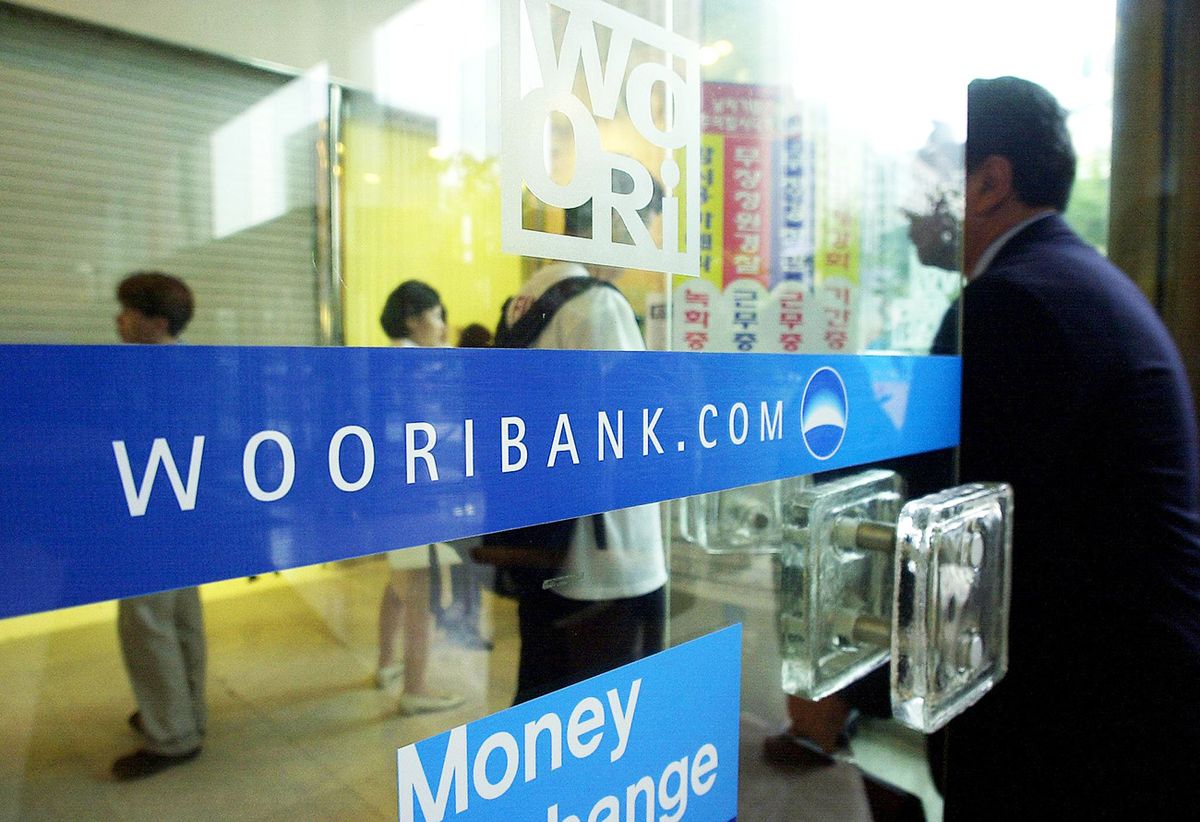 SKOREA-BANKING-WOORI2, South Korean customers enter a Woori bank branch 05 September 2002 in Seoul's financial district. US investment bank Lehman Brothers has signed a one billion dollar investment deal with South Korea's state-run Woori Finance Holdings Co, South Korea's second-biggest financial services group. The contract would help Woori clean up its bad assets and speed its privatization. AFP PHOTO/CHOI JAE-KU (Photo by CHOI JAE-KU / AFP)