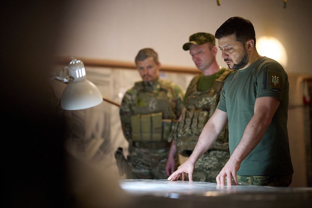 This handout picture taken and released by the Ukrainian Presidential press service on July 8, 2022 shows Ukraine President Volodymyr Zelensky looking at a map during his visit to the position of the Ukrainian army in Dnipro region. (Photo by UKRAINIAN PRESIDENTIAL PRESS SERVICE / AFP)