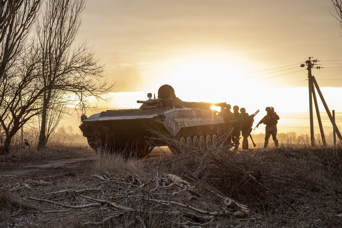 Russian attacks on Ukraine, LUK’YANIVKA, KYIV PROVINCE, UKRAINE, MARCH 28: Ukrainian servicemen take cover behind a military armored vehicle as they walk towards the battlefield in Luk’yanivka, eastern of Kyiv, Ukraine, March 28th, 2022. Narciso Contreras / Anadolu Agency (Photo by Narciso Contreras / ANADOLU AGENCY / Anadolu Agency via AFP)