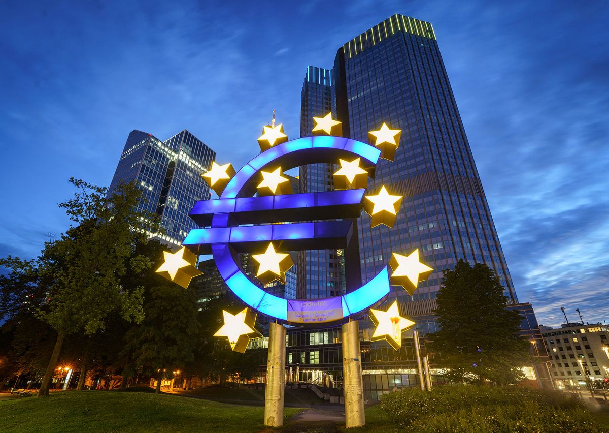 13 July 2022, Hessen, Frankfurt/Main: The large euro symbol in front of the former headquarters of the European Central Bank (ECB, r) glows in the early morning. Photo: Frank Rumpenhorst/dpa (Photo by FRANK RUMPENHORST / DPA / dpa Picture-Alliance via AFP)