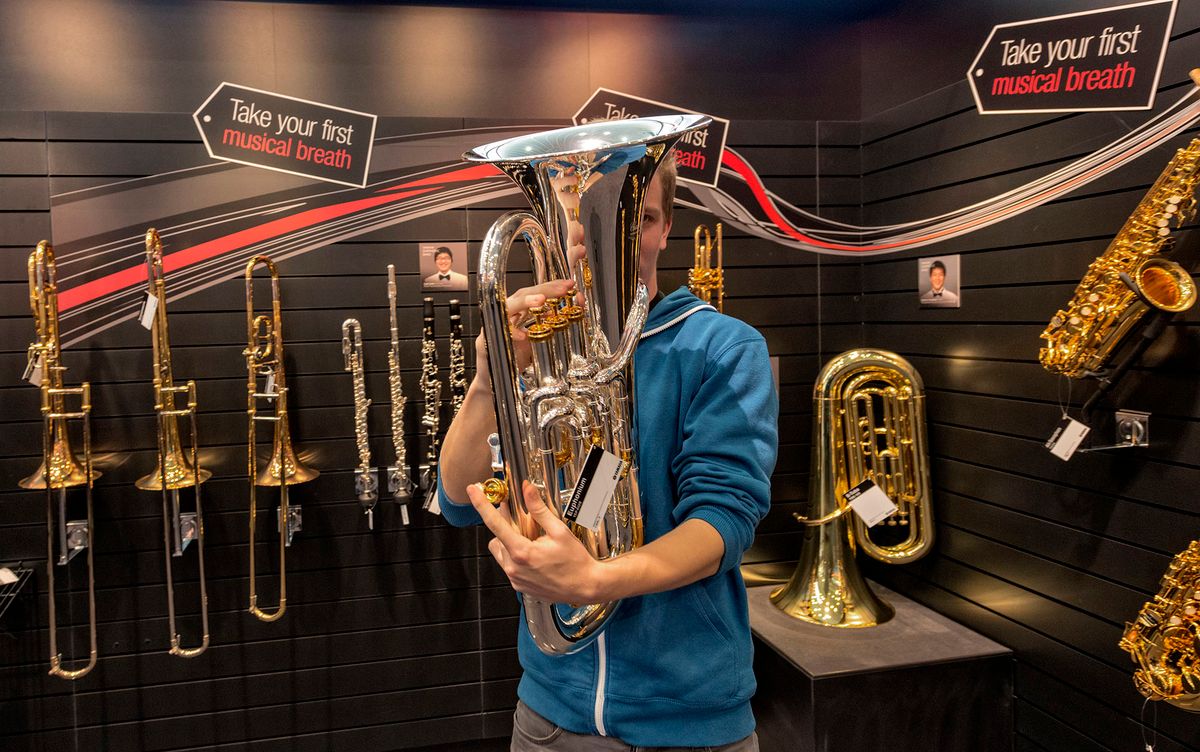 524090206 A visitor checks a tuba at Yamaha pavilion in the Musikmesse 2014, music international trade fair, in Frankfurt, Germany, 12 March 2014. The Musikmesse is the world's leading trade fair for the world of music, showing a complete range of products with everything required for making music, and many workshops, concerts, demonstrations and discussion events. (Photo by Horacio Villalobos/Corbis via Getty Images)