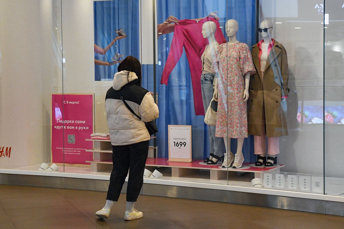 8136690 09.03.2022 A woman looks at a showcase of the closed H&M store in St.Petersburg, Russia. H&M company announced that they temporarily closed their stores in Russia. Alexander Galperin / Sputnik (Photo by Alexander Galperin / Sputnik / Sputnik via AFP)