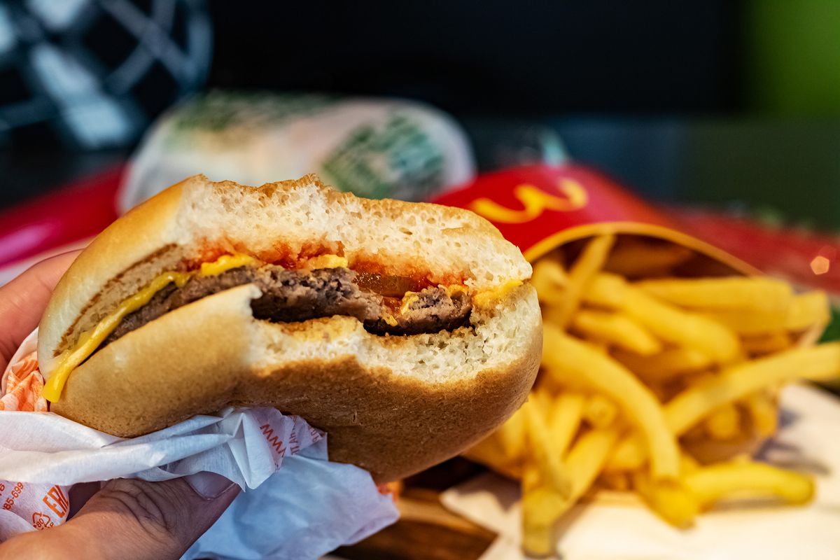 Belarus,,Vitebsk,-,October,21,,2019:,French,Fries,And,Bitten, BELARUS, VITEBSK - OCTOBER 21, 2019: French fries and bitten cheeseburger at mcdonalds