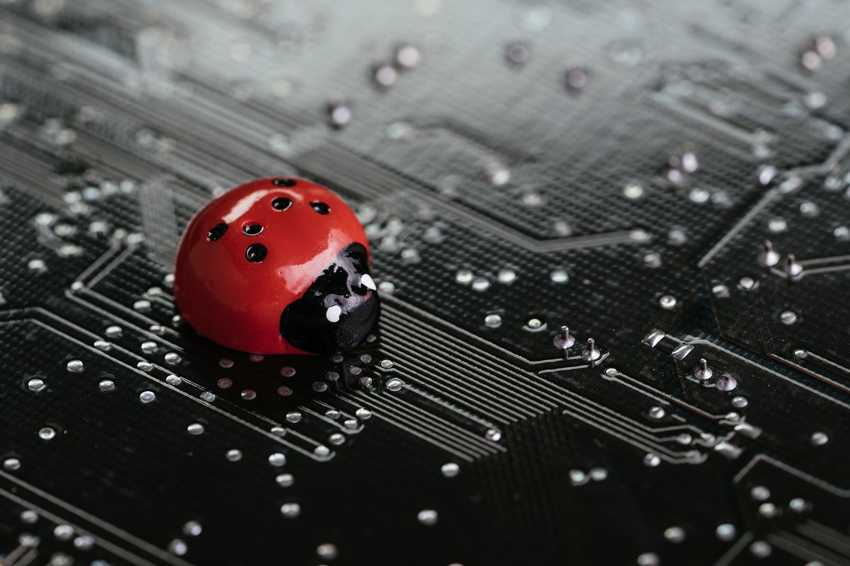 Computer,Bug,,Failure,Or,Error,Of,Software,And,Hardware,Concept, Computer bug, failure or error of software and hardware concept, miniature red ladybug on black computer motherboard PCB with soldering, programmer can debug to search for cause of error. szofter probléma, bug, bogár
