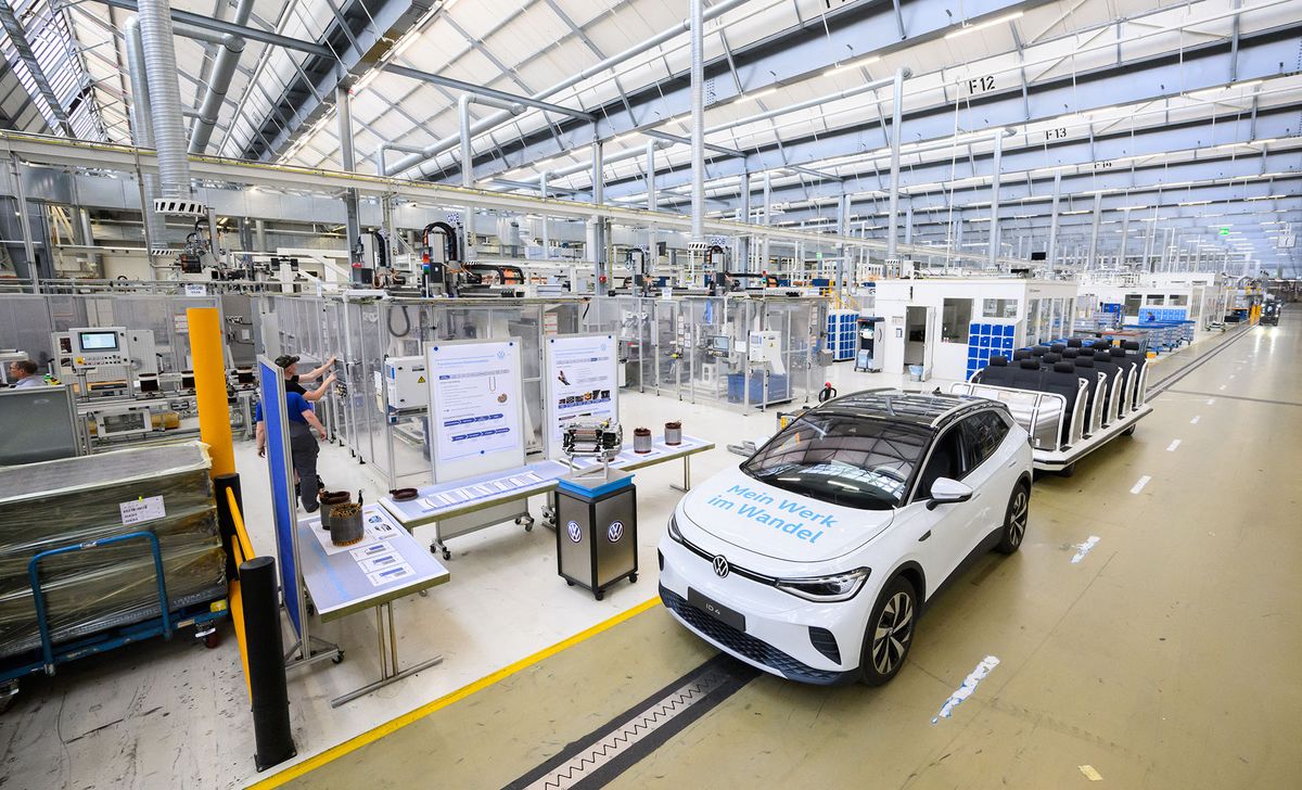 18 May 2022, Lower Saxony, Salzgitter: An APP310-20 electric motor stands next to a VW ID.4 electric car at the VW plant in Salzgitter. Volkswagen is building a battery cell factory at the Salzgitter site for its planned large-scale production of the Group's own battery cells. New battery systems for electric cars are already being developed at the research and development center. Photo: Julian Stratenschulte/dpa (Photo by JULIAN STRATENSCHULTE / DPA / dpa Picture-Alliance via AFP)