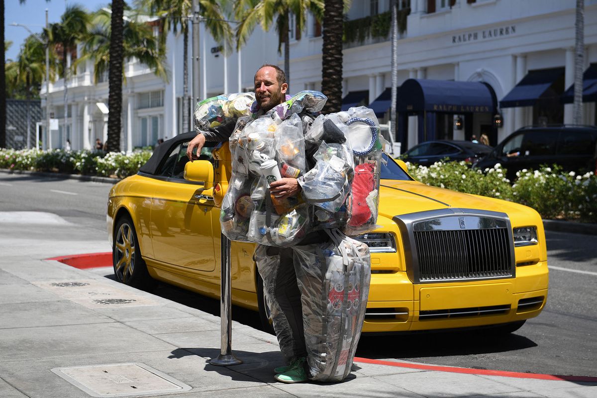 Environmental activist Rob Greenfield walks around Beverly Hills, California May 16, 2022 wearing a suit filled with every piece of trash he has generated living and consuming like a typical American for one month to raise awareness about how much garbage just one person generates. - Greenfield is currently on day 27 of the 30-day project and is wearing 63 lbs (28,5kg) of trash. We all know someone with a rubbish fashion sense, but Rob Greenfield is proud to be wearing garbage -- it's all part of a plan to show just how much trash we unthinkingly throw away every month. The campaigner is wandering the streets of Los Angeles and surrounding cities in a specially designed suit that holds all of the junk he has produced over the last few weeks. (Photo by Robyn Beck / AFP)