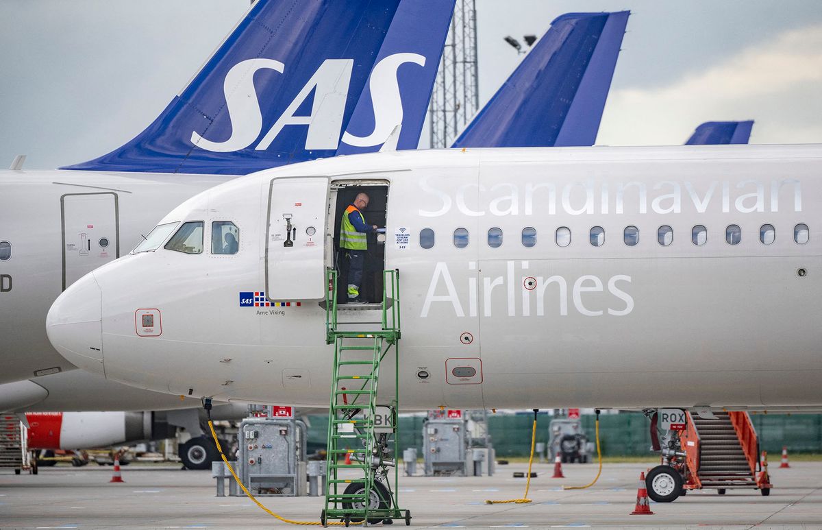 -Technicians are seen on board Scandinavian airline SAS aircraft parked at Kastrup airport on July 4, 202 after the 900 pilots at SAS went on strike. - Scandinavian airline SAS said that negotiations between the carrier and the pilots' union had failed to reach an agreement, prompting some 900 pilots to strike. (Photo by Johan NILSSON / TT News Agency / AFP) / Denmark OUT