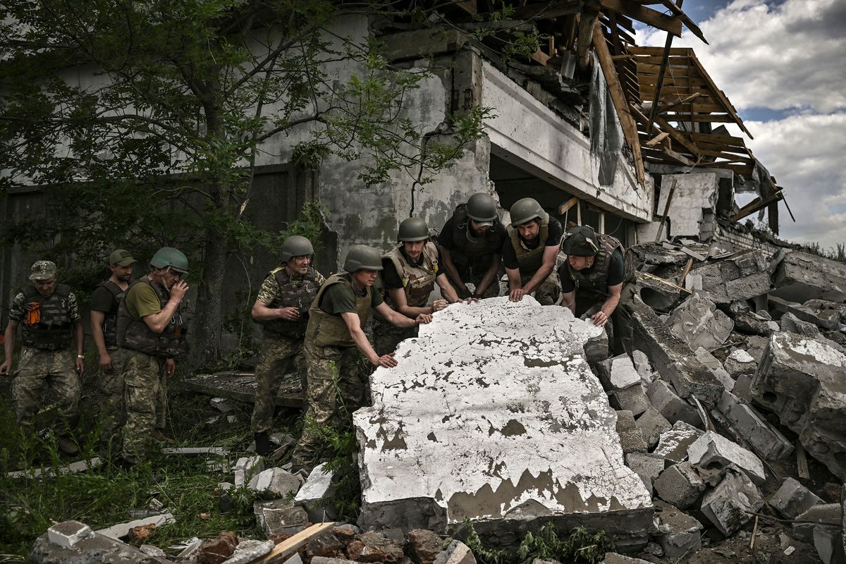 Ukrainian soldiers inspect a destroyed warehouse reportedly targeted by Russian troops on outskirts of Lysychansk, in the eastern Ukrainian region of Donbas on June 17, 2022, as the Russian-Ukraine war enters its 114th day. (Photo by ARIS MESSINIS / AFP)