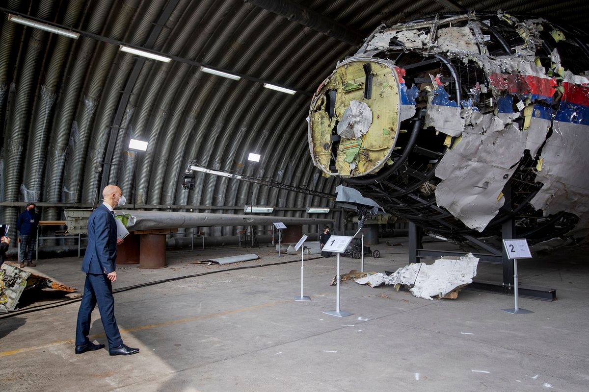 Presiding judge Hendrik Steenhuis (L) views the reconstructed wreckage of Malaysia Airlines Flight MH17, at the Gilze-Rijen military airbase, southern Netherlands on May 26, 2021. - Judges inspect wreckage of flight MH17 as part of criminal trial of four suspects. (Photo by Peter Dejong / POOL / AFP)
