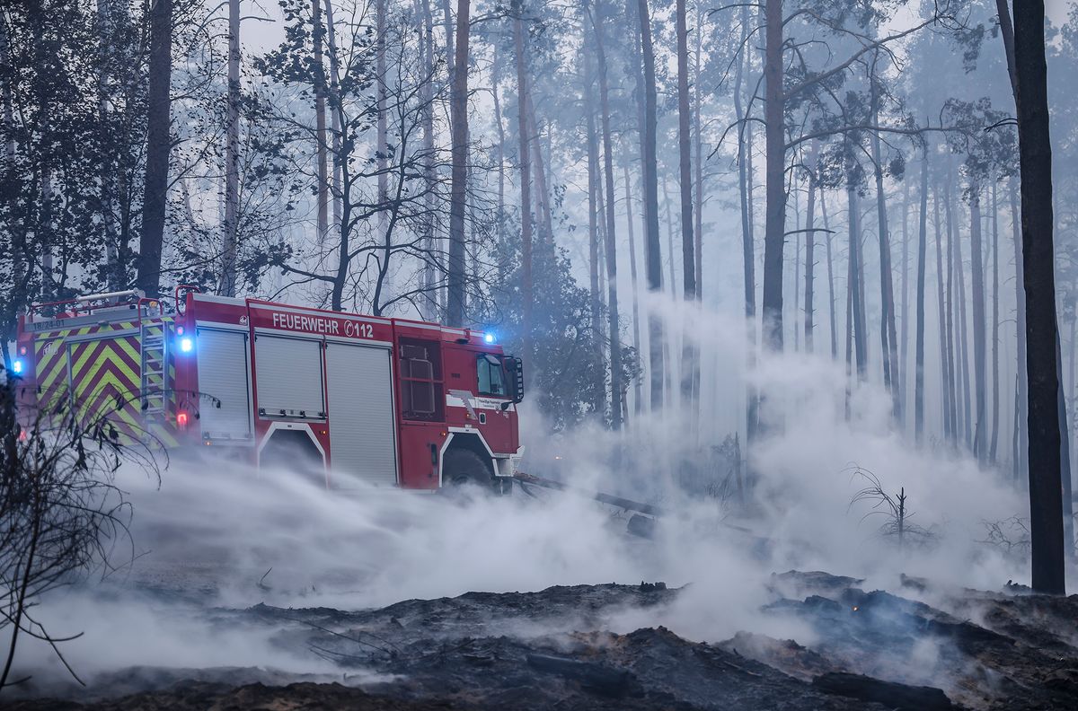 Brandenburg forest fires, dpatop - 26 July 2022, Brandenburg, Falkenberg: Firefighters extinguish a forest fire. Firefighters in Brandenburg continue to battle a large forest fire in the Elbe-Elster district. It burns over an area of 800 hectares. The first residents of the Kölsa settlement in Falkenberg and Rehfeld had to leave their homes. Photo: Jan Woitas/dpa (Photo by Jan Woitas/picture alliance via Getty Images)