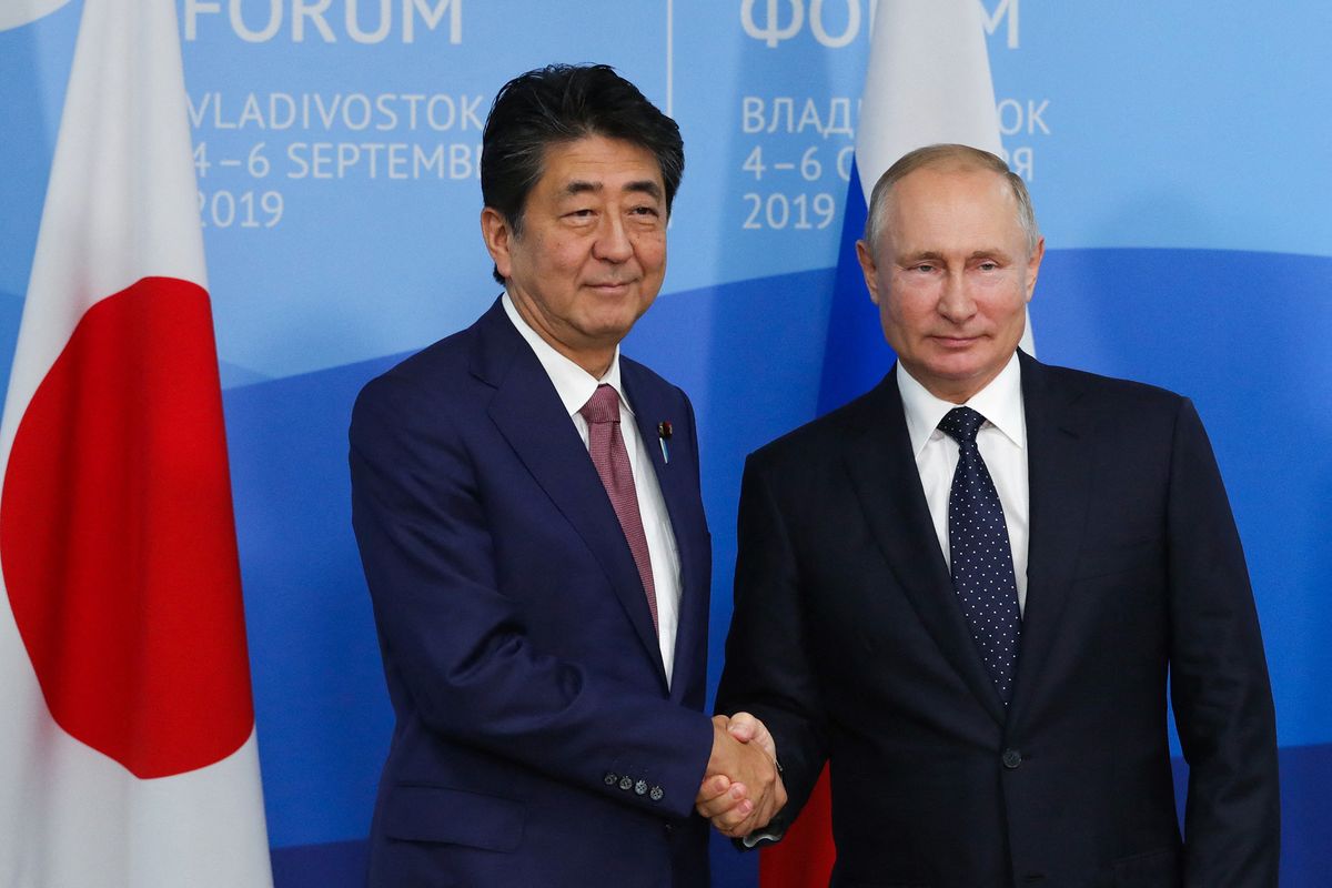 Russian President Vladimir Putin (R) shakes hands with Japan's Prime Minister Shinzo Abe during their meeting at the Eastern Economic Forum in Vladivostok on September 5, 2019. (Photo by Mikhail KLIMENTYEV / SPUTNIK / AFP)