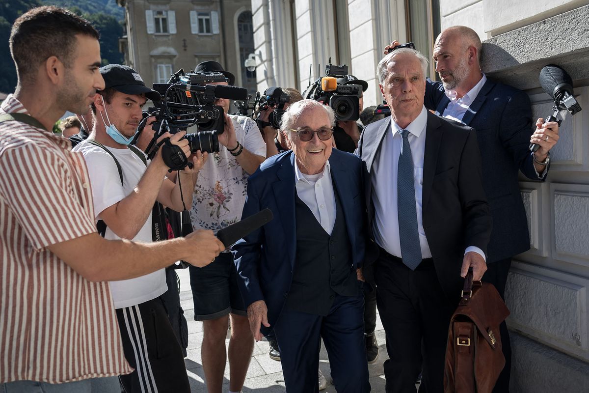 Former FIFA president Sepp Blatter (C), surrounded by journalists, arrives to Switzerland's Federal Criminal Court to listen the verdict of his trial over a suspected fraudulent payment, in the southern Switzerland city of Bellinzona, on July 8, 2022. - The Bellinzona court will hand down its verdict in the trial of former UEFA president Michel Platini and former FIFA president Sepp Blatter. Blatter and Platini are being tried over a two-million-Swiss-franc ($2 million) payment in 2011 to the former France captain, who by that time was in charge of European football's governing body UEFA. (Photo by Fabrice COFFRINI / AFP)