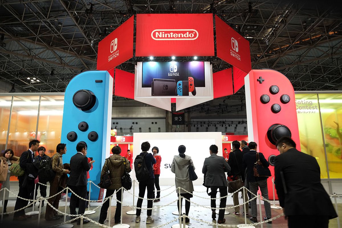People make line up for Nintendo's new video game console Switch during its presentation in Tokyo on January 13, 2017. - Nintendo on January 13 unveiled its new Switch game console, which works both at home and on-the-go, as it looks to offset disappointing Wii U sales and go head to head with rival Sony's hugely popular PlayStation 4. (Photo by Kazuhiro NOGI / AFP)