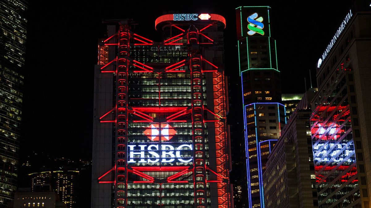 This picture taken on November 4, 2016 shows the illuminated HSBC logo at night on the facade of the HSBC headquarters building in Hong Kong. - HSBC said on November 7 its third quarter adjusted pretax profit rose seven percent from a year ago to USD 5.59 billion, beating expectations. (Photo by ANTHONY WALLACE / AFP)