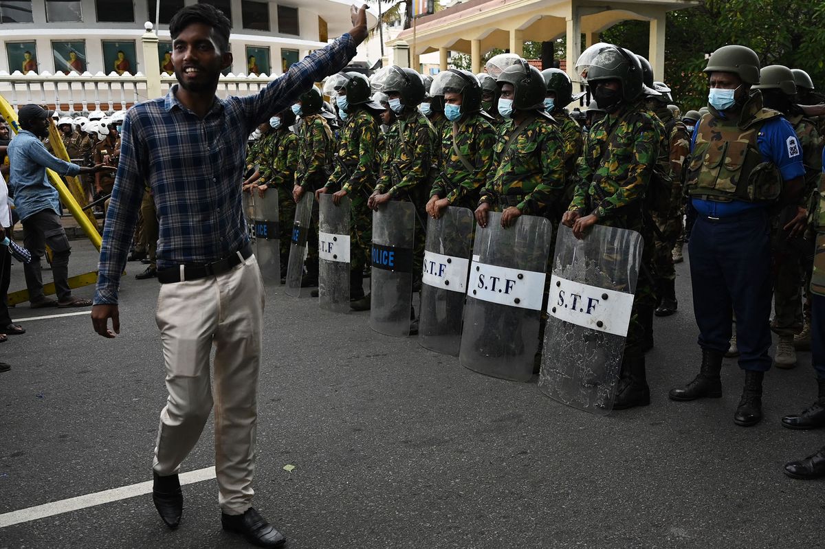 A demonstrator shouts slogans in front of Police special task force personnel standing guard while blocking a road during a protest march against Sri Lankan President Ranil Wickremesinghe towards the Presidential Secretariat building in Colombo on July 22, 2022. - Sri Lankan security forces demolished the main anti-government protest camp in the capital, evicting activists in a pre-dawn assault on July 22 that raised international concern for dissent under the new pro-West president. (Photo by Arun SANKAR / AFP)