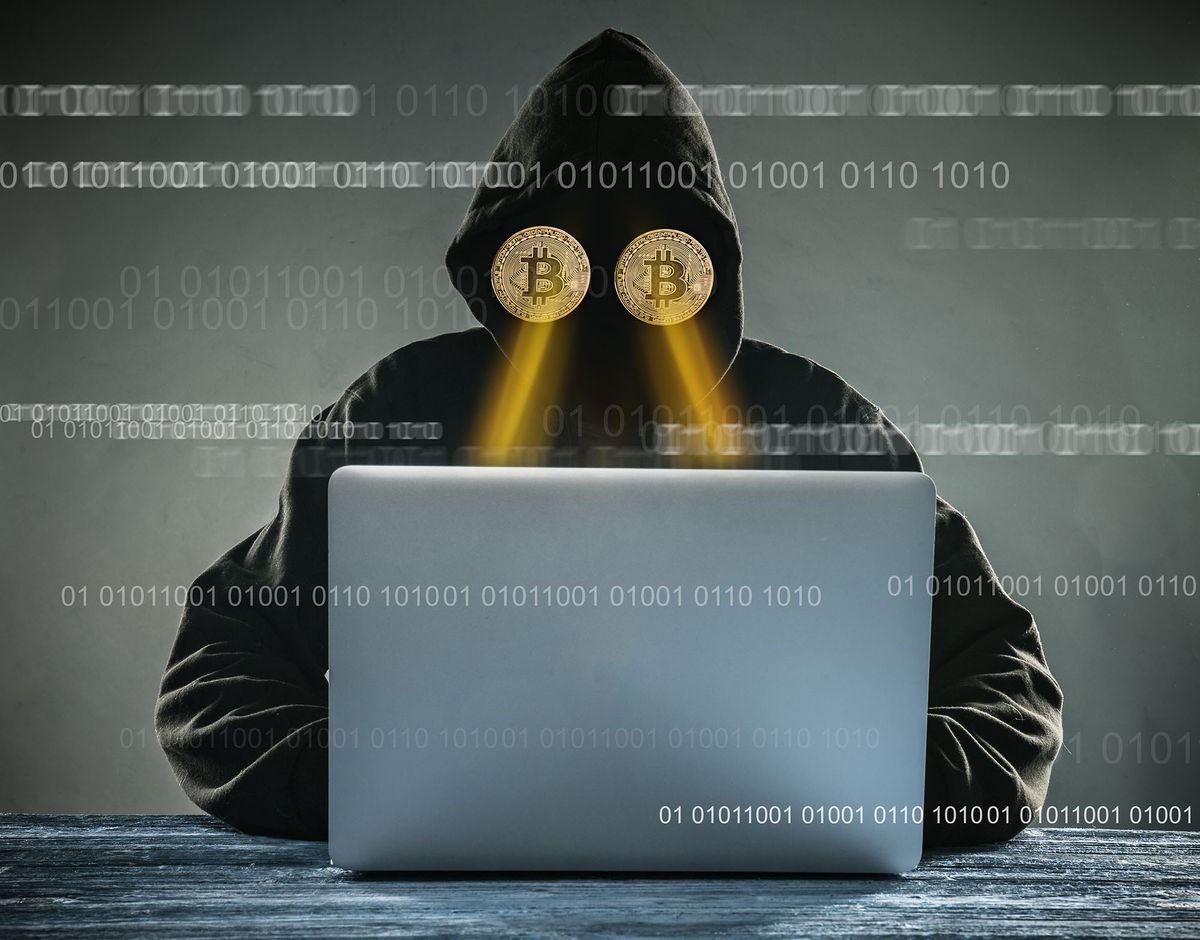 kriptovalutát bányászó hekkerek Anonymous person sitting behind laptop having gold bitcoins instead of eyes Virtual cryptocurrency concept.