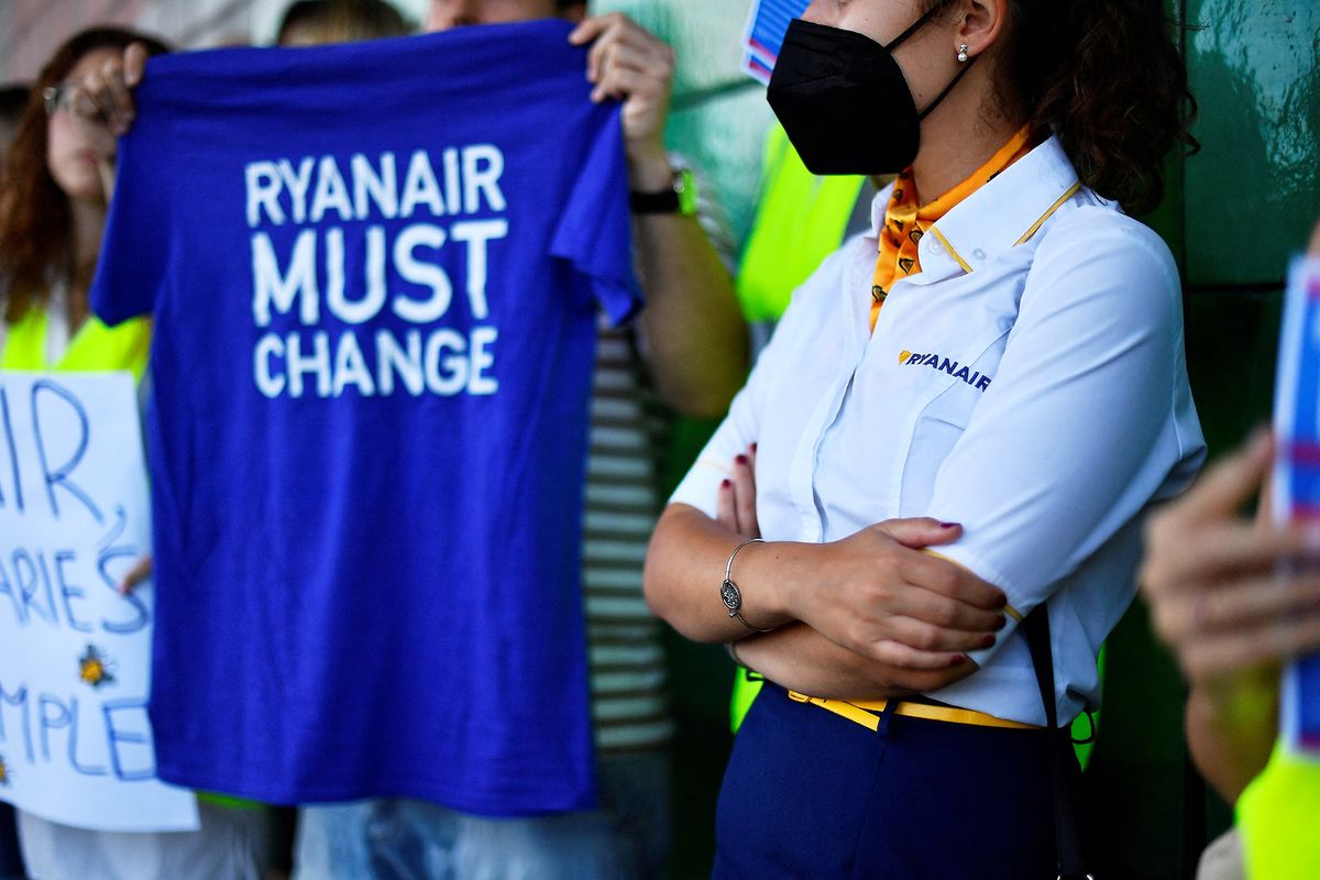 A Ryanair employee wearing the cabin crew uniform takes part in a protest at the Terminal 2 of El Prat airport in Barcelona on June 24, 2022. - Trade unions representing Ryanair cabin crew in Belgium, France, Italy, Portugal and Spain have called for strikes this coming weekend, while easyJet's operations in Spain face a nine-day strike next month. (Photo by Pau BARRENA / AFP)