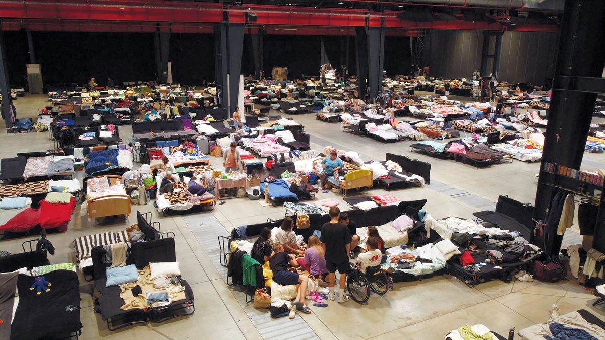 An elevated view taken on July 15, 2022 shows Ukrainian refugees at the Humanitarian Aid Center set up at the Global Expo exhibition hall in Warsaw on July 15, 2022. - The makeshift refugee centre was meant to be a temporary solution but as the war drags on, their lives are still on hold. (Photo by Damien SIMONART / AFP) / TO GO WITH AFP STORY BY NELL SAIGNES