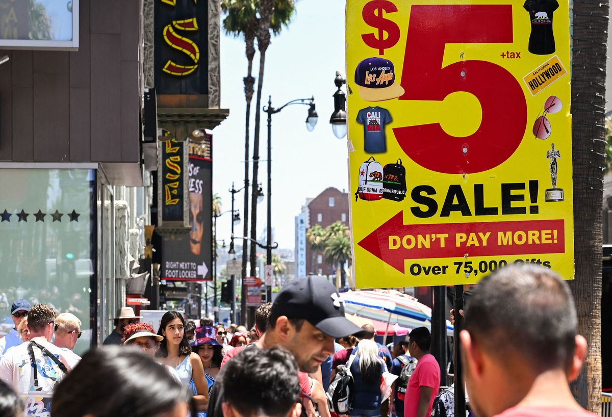(FILES) In this file photo taken on July 13, 2022, sign outside a souvenir shop advertises items on sale for five dollars as tourists walk along Hollywood Boulevard in Los Angeles. - US retail sales shot up in June amid the ongoing surge in prices, according to new data on July 15, 2022, that spelled more bad news for the Federal Reserve as it struggles to rein in rampant inflation. The data showed that after pausing in May, US consumers last month were still eating out and buying furniture and cars, even amid the fastest inflation in more than four decades. (Photo by Patrick T. FALLON / AFP)