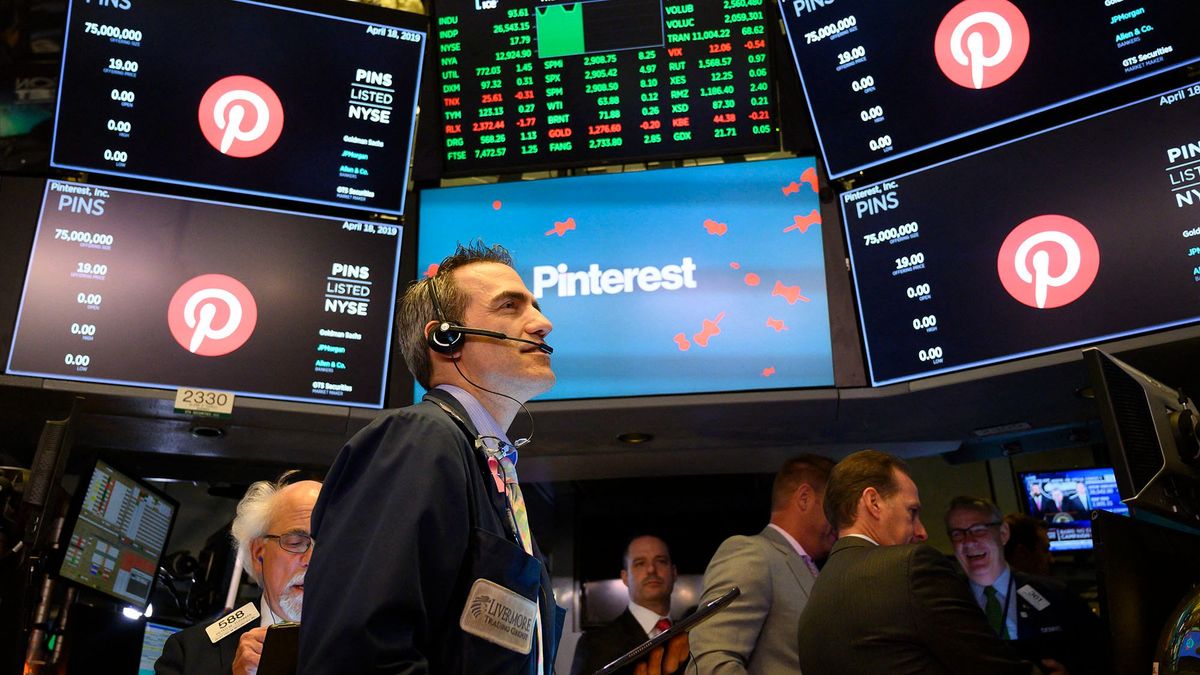 Traders work after the opening bell at the New York Stock Exchange (NYSE), while logo for Pinterest Inc. is pictured on the screens during the company's IPO on April 18, 2019 in New York City. (Photo by Johannes EISELE / AFP)