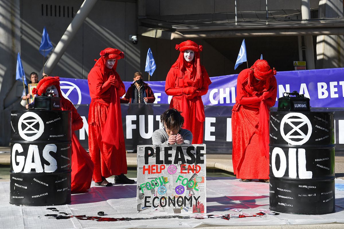 Members of the Red Rebel Brigade - an international performance artivist troupe - join climate activists from the Extinction Rebellion protest group, as they demonstrate against fossil fuel use, outside of the Scottish Parliament Building in Edinburgh on April 1, 2022. (Photo by ANDY BUCHANAN / AFP)