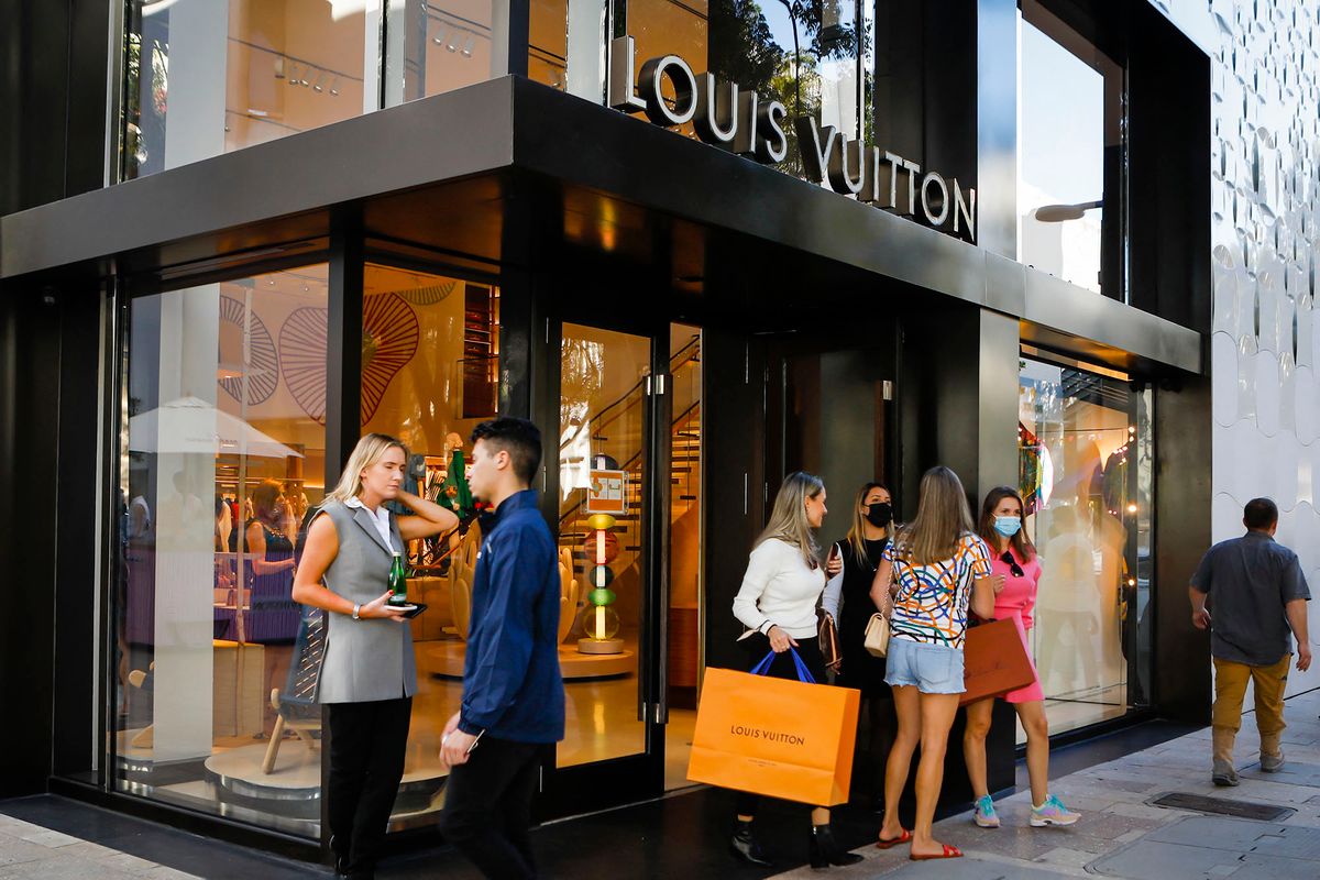 Shoppers exit the Louis Vuitton store in Miami, Florida on November 30, 2021. - Artistic director for Louis Vuitton men's collections, Abloh, whose family was from Ghana, died on November 28 of cancer aged 41, after becoming the first major black designer to be recognised in an industry often criticised for its lack of diversity. (Photo by Eva Marie UZCATEGUI / AFP)