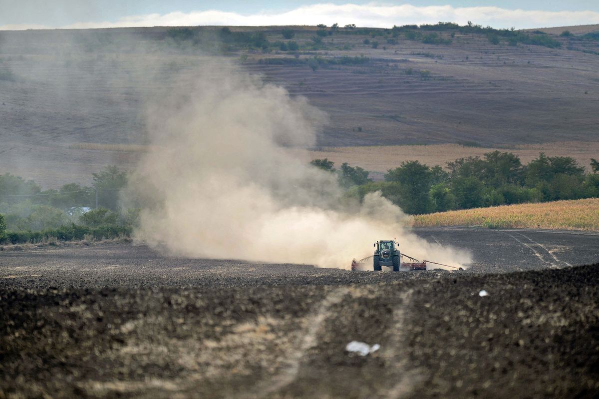 A tractor raises dust as it ploughs dry farmland close to Barlad city (250km northeast from Bucharest) on September 8, 2012. After severe snow storms of last winter and spring Romania's climate shifts to drought of this summer, caused by an unusually long heat wave. Drought has ravaged crops, vegetables, fruit, and power production and is thought to be the worst in the past four decades. AFP PHOTO/ DANIEL MIHAILESCU (Photo by DANIEL MIHAILESCU / AFP)
