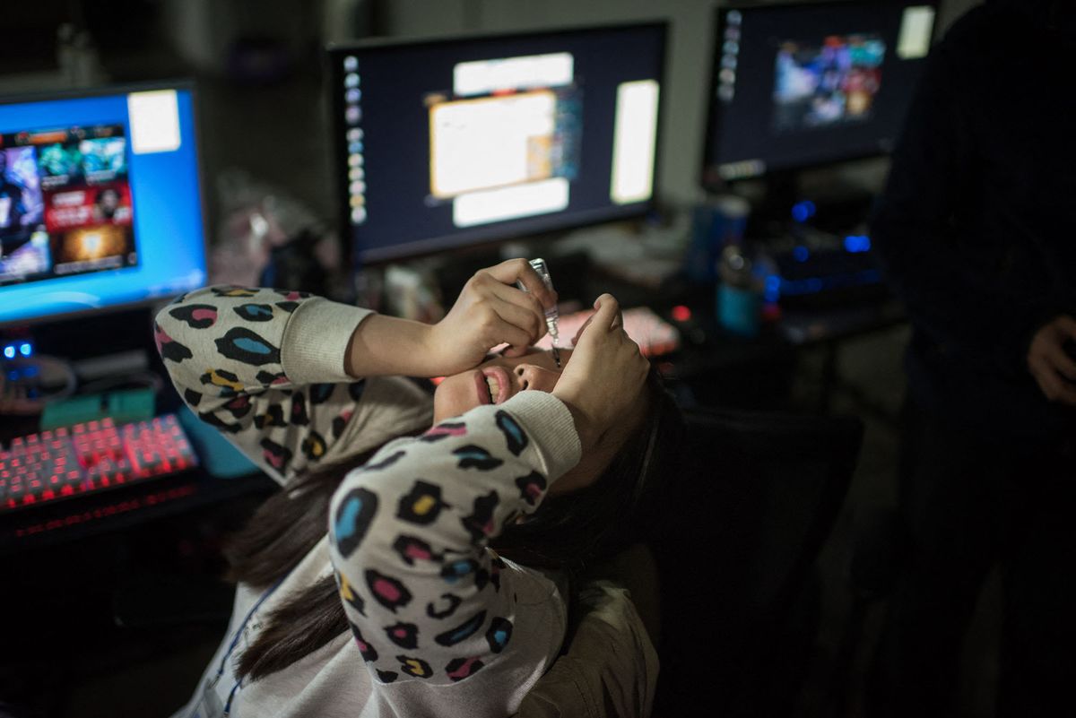 In a photo taken on April 11, 2016 Min-Bin Shin (21) of the all-female computer gaming team 'QWER' uses eye drops as she sits at her computer at an office used as a training venue for their team, in Seoul. - Brought together by a Seoul-based startup, the team trained intesively for a week prior to competing in the 'Ladies Battle, an all-female League of Legends competition. In keeping with a format used by most proffessional male teams, the members of 'QWER' lived together during the training period which involved playing the game for hours on end followed by lengthy review sessions with freelance mentors and former League of Legends champions. Despite South Korea's top-tier gaming credentials proffessional female teams are a minority. But for those who excel at the strategy-based, multi-player game, international competitions can lead to high cash rewards, and the chance to sign on with prominent foreign teams. Internet-based competitive gaming, or e-sports, in South Korea is widespread, with professional teams often attracting sponsorship from the country's largest tech companies. The country has long promoted its internet technology as a key driver of growth; with Seoul often referred to as the "most wired" city on the planet. (Photo by ED JONES / AFP)