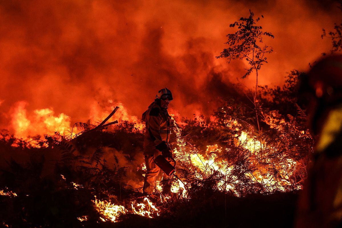 A tactical firefighter set fires to burn a plot of land as firefighters attempt to prevent the wild fire from spreading due to wind change, as they fight a forest fire near Louchats in Gironde, southwestern France on July 17, 2022. - France was on high alert on July 18, 2022, as the peak of a punishing heatwave gripped the country, while wildfires raging in parts of southwest Europe showed no sign of abating. In the southwestern Gironde region, firefighters over the weekend continued to fight to control forest blazes that have devoured nearly 11,000 hectares (27,000 acres) since July 12. (Photo by THIBAUD MORITZ / AFP)