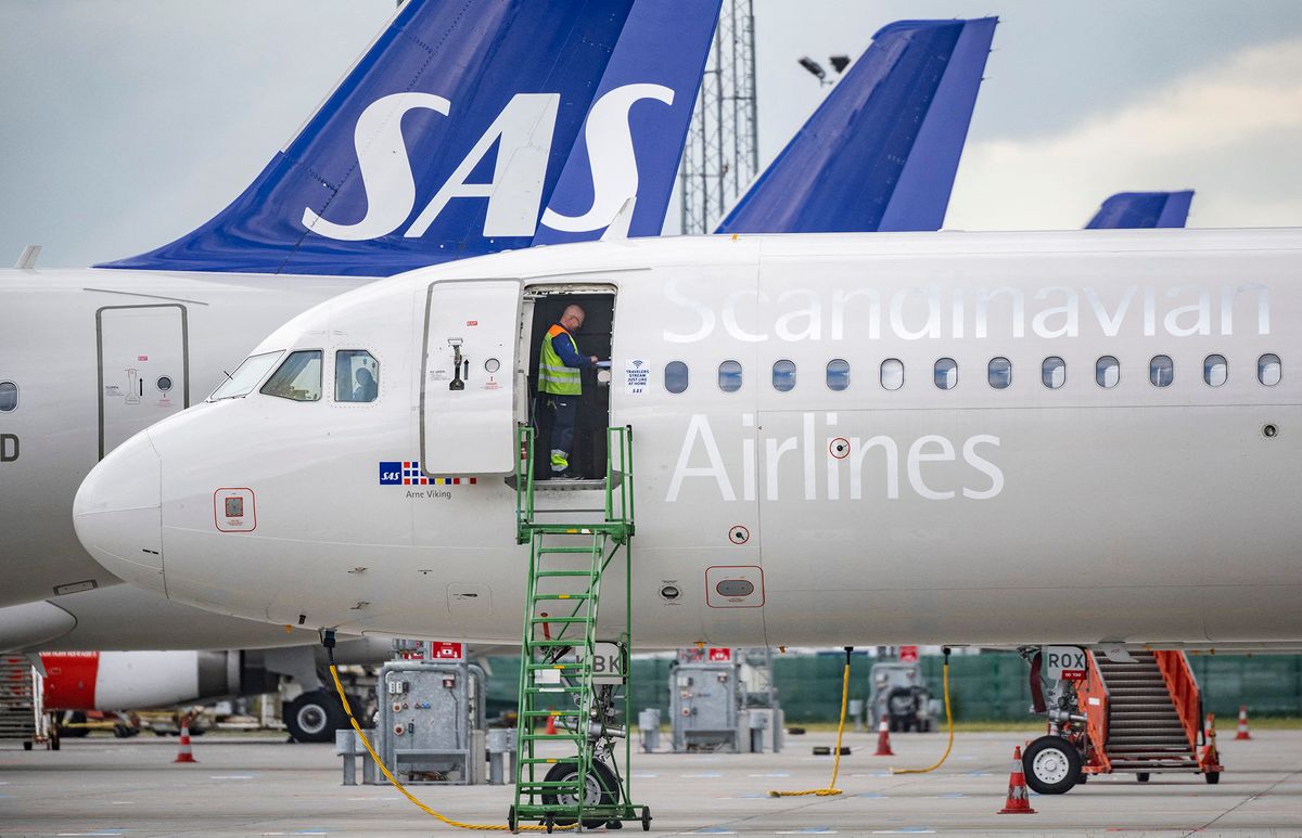Technicians are seen on board Scandinavian airline SAS aircraft parked at Kastrup airport on July 4, 202 after the 900 pilots at SAS went on strike. - Scandinavian airline SAS said that negotiations between the carrier and the pilots' union had failed to reach an agreement, prompting some 900 pilots to strike. (Photo by Johan NILSSON / TT News Agency / AFP) / Denmark OUT