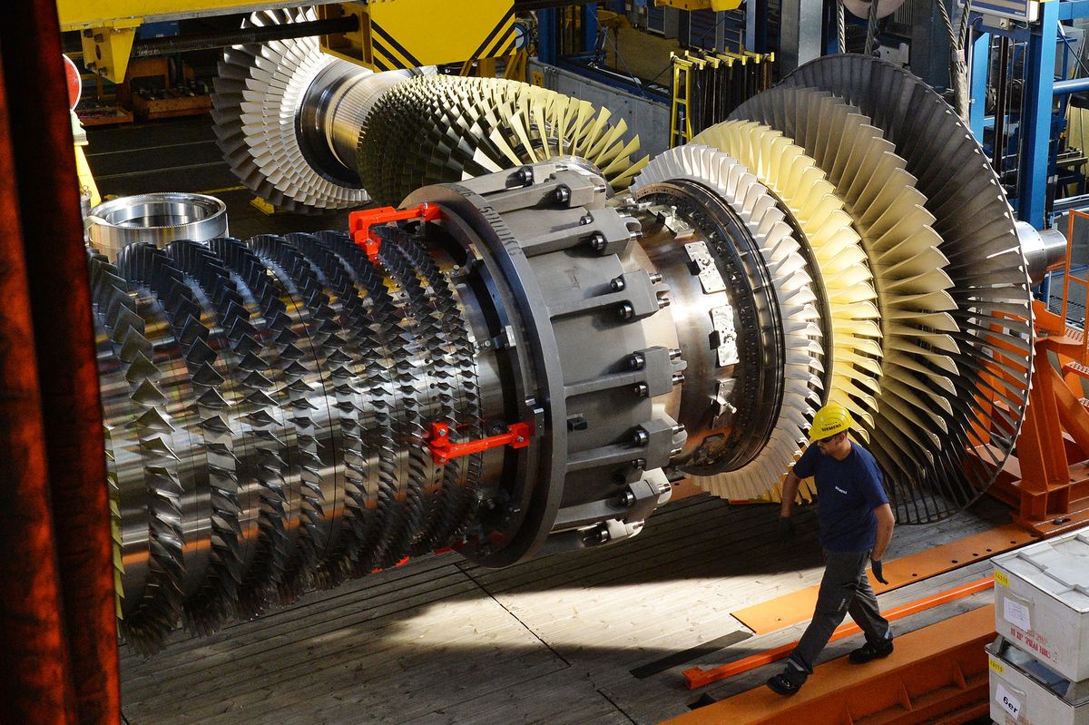 Siemens workers monitor a turbine rotor in a gas turbine in Berlin, Germany, 16 September 2016. Photo: Maurizio Gambarini/dpa (Photo by MAURIZIO GAMBARINI / DPA / dpa Picture-Alliance via AFP)