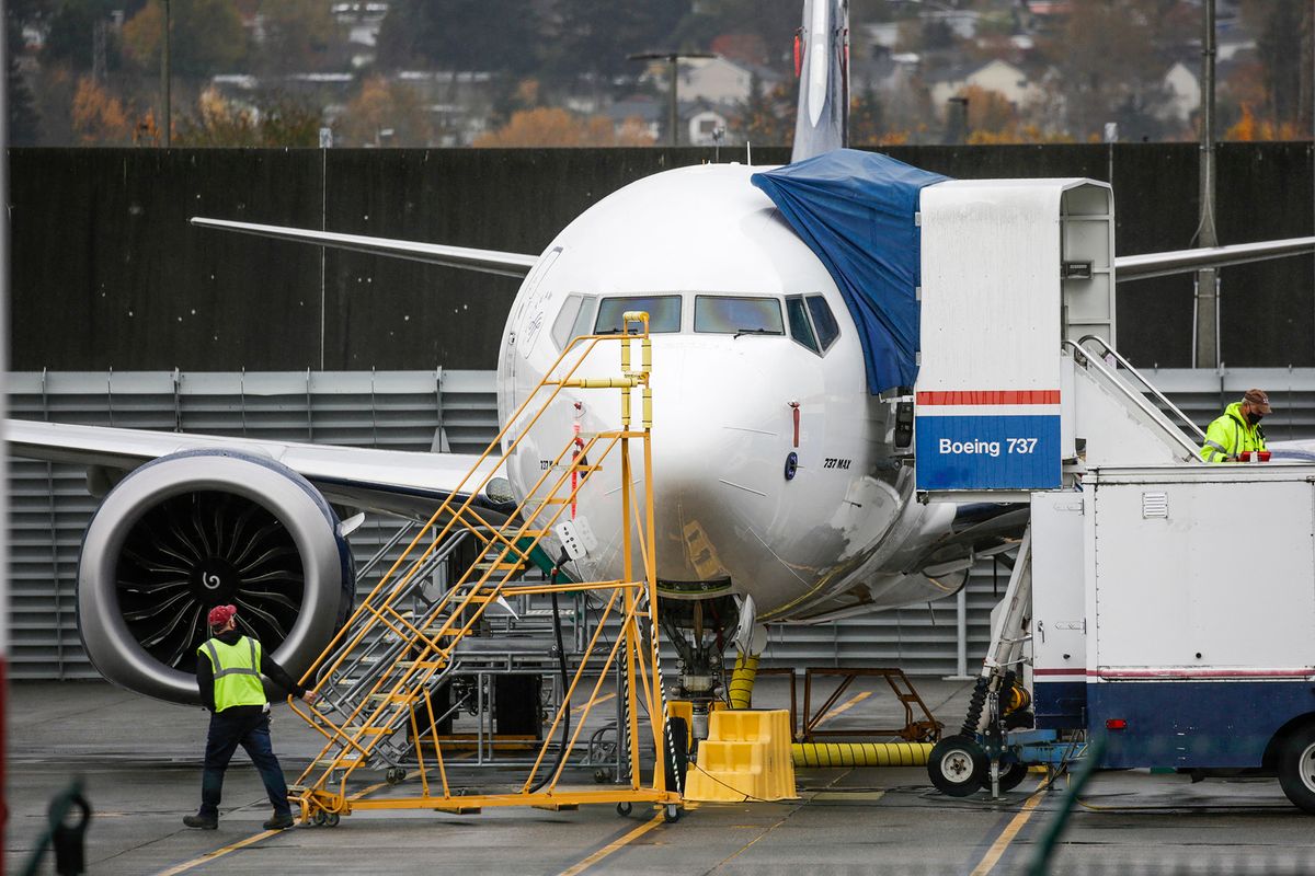 Workers are pictured near a Boeing 737 MAX airliner at Renton Airport adjacent to the Boeing Renton Factory in Renton, Washington on November 10, 2020. - Boeing said November 10, 2020 it was hit with another 12 cancelled orders for the 737 MAX, as the flagship aircraft is close to returning to the skies after being grounded since March 2019 following two deadly crashes. (Photo by Jason Redmond / AFP)