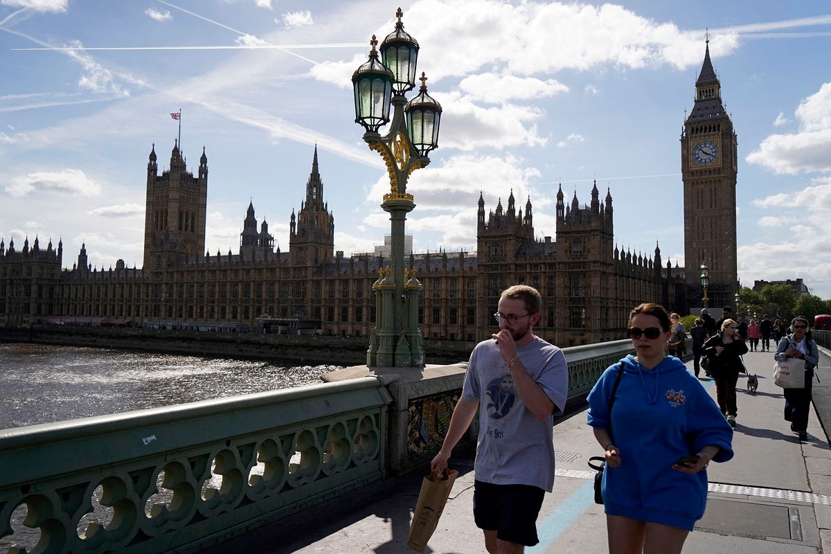 Pedestrians cross Westminster Bridge over the River Thames away from the Palace of Westminster in the afternoon sunshine in London on May 10, 2022 (Photo by Niklas HALLE'N / AFP)