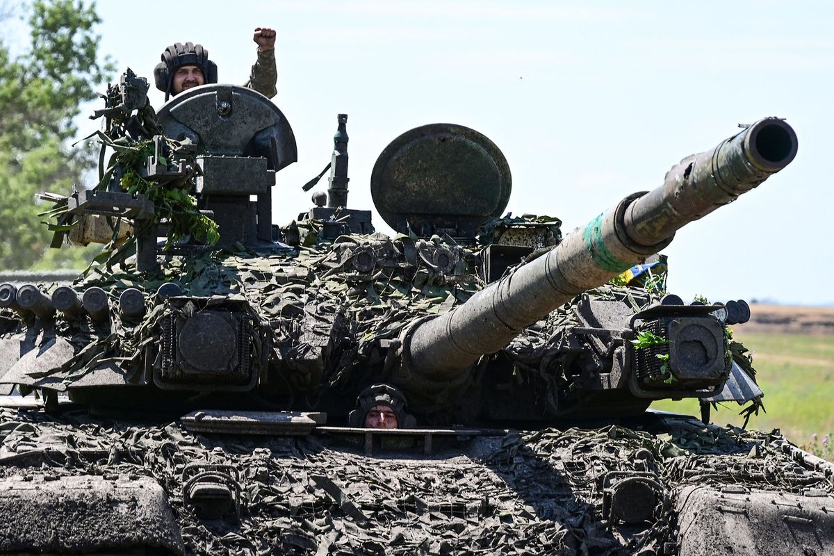 Ukrainian servicemen drive a T-72 tank on the frontline in eastern Ukraine on July 13, 2022, amid the Russian invasion of Ukraine. (Photo by MIGUEL MEDINA / AFP)