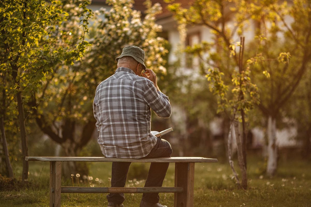 nyugdíjemelés nyugdíjas idős öreg 1384557588 Old man sitting on a wooden bench in his back yard and reading a book in peace.