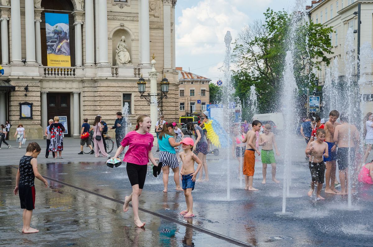 LVIV, UKRAINE - JUNE 8: Children bathe in the fountain to cool off near the Opera House in hot weather in Lviv, Ukraine, June 8, 2022 as Russia-Ukraine war continues. Olena Znak / Anadolu Agency (Photo by Olena Znak / ANADOLU AGENCY / Anadolu Agency via AFP)