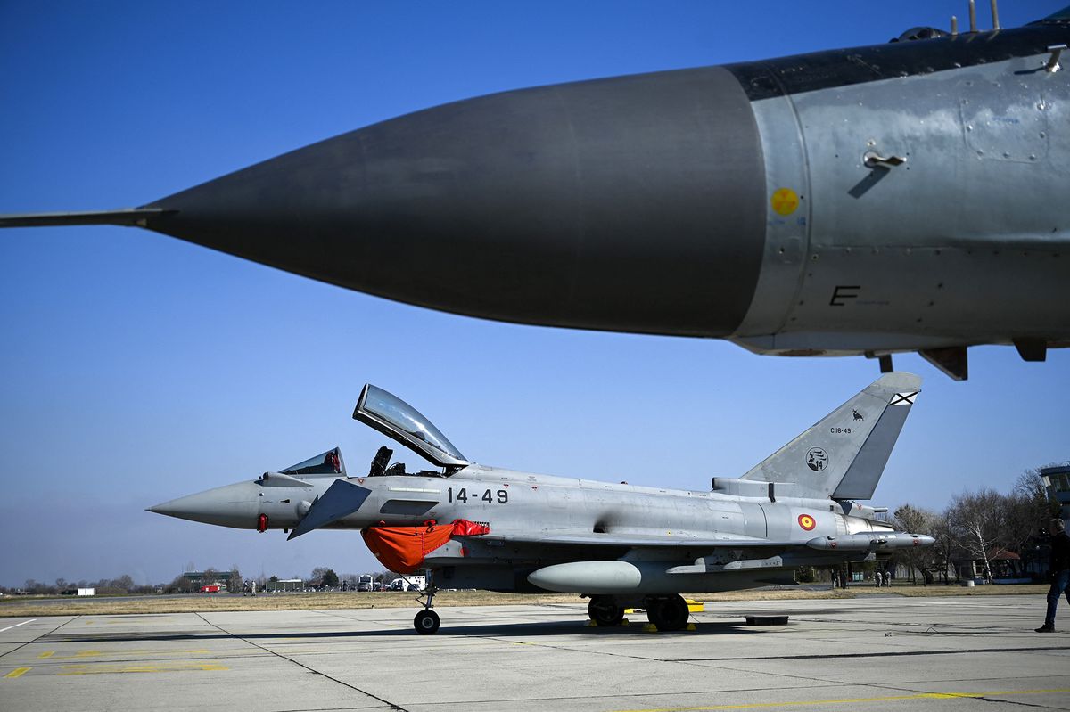 A photograph shows a Spanish Eurofighter EF-2000 Typhoon II  next to a Bulgarian Air Force MiG-29 at Graf Ignatievo airbase near Plovdiv on February 21, 2022. - Spain has deployed four fighter jets to fellow NATO member Bulgaria. NATO allies have put forces on standby and sent ships and fighter jets to bolster Europe's eastern defences as tensions soar over Russia's military buildup around Ukraine. (Photo by Nikolay DOYCHINOV / AFP)