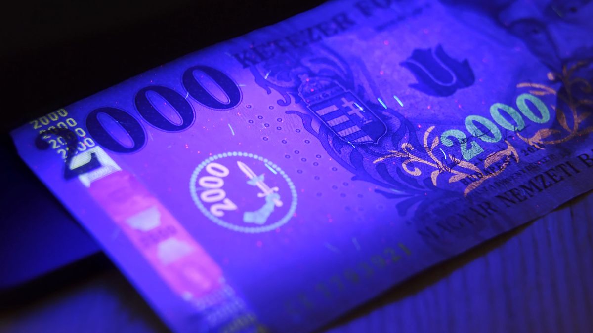 Warsaw, Poland 01.01.2021 2000 hungarian forint banknote being tested for counterfeiting under the UV lamp. anti-counterfeiting technology used to prevent fraud and money malversation. High quality