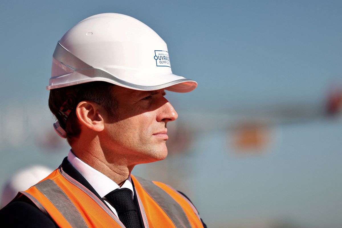 French President Emmanuel Macron, wearing a working helmet, visits the building site of the Olympic Village in Saint-Ouen on October 14, 2021, as part of a visit to construction sites dedicated to Paris 2024 Olympic and Paralympic Games in Seine-Saint-Denis, Paris suburb. - A plan to build 5,000 small local sports facilities for an amount of 200 million euros will be launched by 2024 to facilitate in particular new sports practices such as skateboarding or 3X3 basketball, the Elysee announced on October 13, 2021. (Photo by SARAH MEYSSONNIER / POOL / AFP)