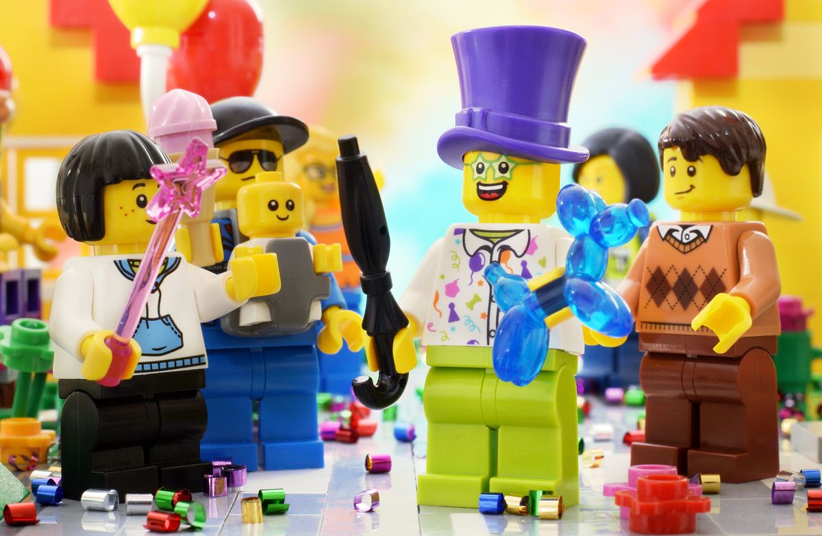 Lörrach, Germany - April 30th 2021: Lego minifigures clown in purple cup and girl on the street parade or carnival. Editorial illustrative image of carnival.