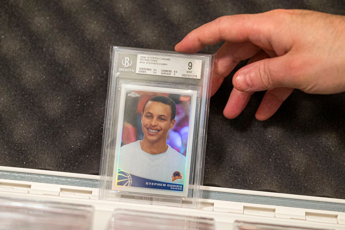 A trader shows a sport card of NBA player Stephen Curry at Bleecker Trading in New York on July 06, 2021. - Inside an unassuming store in New York's Greenwich Village, several men unlock black briefcases, remove sports cards and begin to trade them -- a growing hobby and industry that has boomed during the pandemic. Excitement is high after a San Francisco-based investment fund announced earlier that day that it had bought a card of Golden State Warriors' basketball star Stephen Curry for $5.9 million, setting a new record. (Photo by Kena Betancur / AFP)