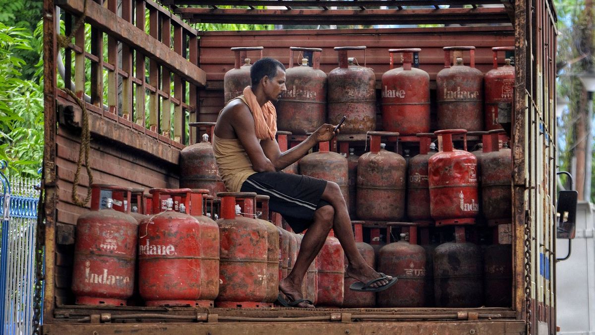 India - Economy, A worker browse mobile phone sitting on a cooking gas cylinder in a truck in Kolkata, India, 01 July, 2021. LPG cylinder price in West Bengal (Kolkata) stands at Rs. 835.50. LPG cooking gas cylinder price hike by Rs 25 according to an Indian media report.   (Photo by Indranil Aditya/NurPhoto) (Photo by Indranil Aditya / NurPhoto / NurPhoto via AFP)