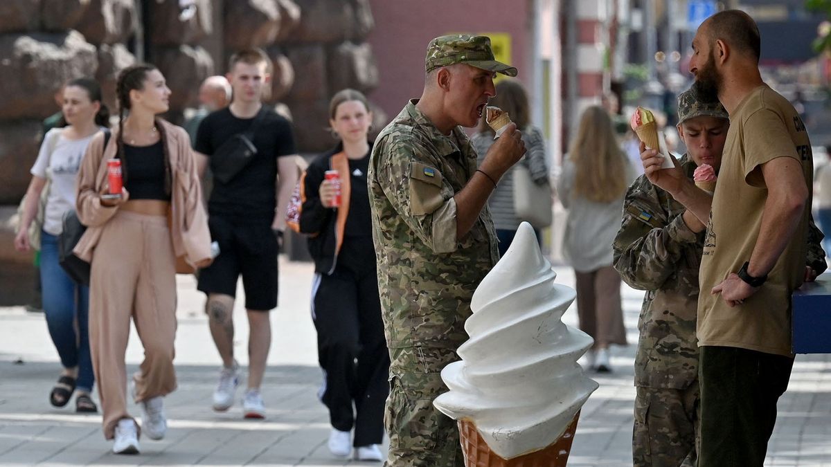 Ukrainian soldiers eat ice-creams in Kyiv city centre on July 7, 2022. (Photo by Sergei SUPINSKY / AFP)