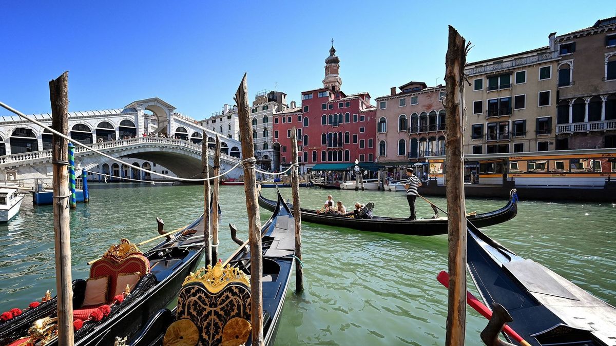 People take a gondola ride by the Rialto Bridge on the Grand Canal in Venice on September 9, 2020, on the eighth day of the 77th Venice Film Festival, during the COVID-19 infection, caused by the novel coronavirus. - It's been a bad year for Venice. In November, the highest tides in over 50 years left it submerged -- the famous Italian lagoon city drenched, despondent and economically devastated. Fast forward to February when the surrounding region, Veneto, saw Italy's first death from coronavirus -- an epidemic that went on to kill over 35,000 people in the country. Finally this month, the opening of the prestigious Venice film festival on September 2 was trumpeted as a sign of hope and renewal for the beloved yet beleaguered city. (Photo by Alberto PIZZOLI / AFP)