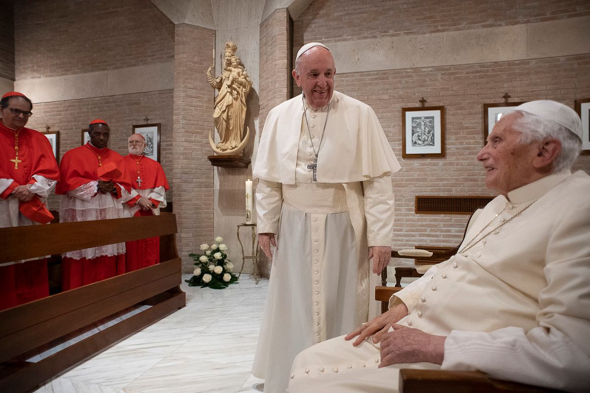 This photo taken and handout on November 28, 2020 by The Vatican Media shows Pope Francis (C) and Pope Emeritus Benedict XVI (R) meeting with new Cardinals following a consistory to create 13 new cardinals, on November 28, 2020 in The Vatican. (Photo by Handout / VATICAN MEDIA / AFP) / RESTRICTED TO EDITORIAL USE - MANDATORY CREDIT "AFP PHOTO / VATICAN MEDIA" - NO MARKETING - NO ADVERTISING CAMPAIGNS - DISTRIBUTED AS A SERVICE TO CLIENTS