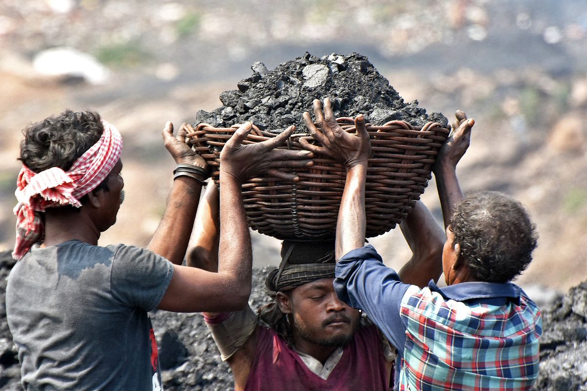 In this picture taken on October 14, 2021, workers prepare to load coal onto a truck at the Jharia coalfield in Dhanbad in India's Jharkhand state. - Asia-Pacific accounts for about three-quarters of global coal consumption -- even as the region struggles with the environmental and public health impacts of global warming, from deadly levels of air pollution in India to extreme heatwaves and wildfires in Australia. (Photo by Gautam Dey / AFP) / TO GO WITH Climate-UN-COP26-Asia-coal,FEATURE by Haeril Halim and Sam Reeves