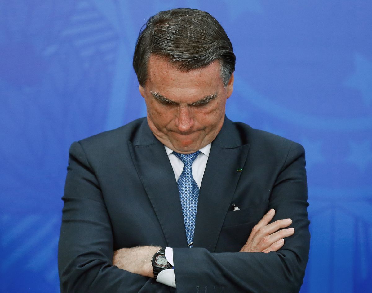 (FILES) In this file photo taken on July 6, 2022, Brazilian President Jair Bolsonaro gestures during a tribute to the Brazilian athletes who won the second place in the general medal table of the Normandy 2022 Gymnasiade in Brasilia. - Brazilian President Jair Bolsonaro got into an altercation on Thursday August 18, 2022 with a social media personality who questioned and insulted him, grabbing the man by the shirt and arm after he called him a "bum." (Photo by  / AFP)
