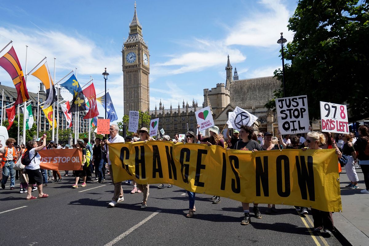 Demonstrators hold placards and banners as they take part in a protest march arriving in Parliament Square, in London, on July 23, 2022 to demand action over the cost of living crisis and the climate change crisis. (Photo by Niklas HALLE'N / AFP)