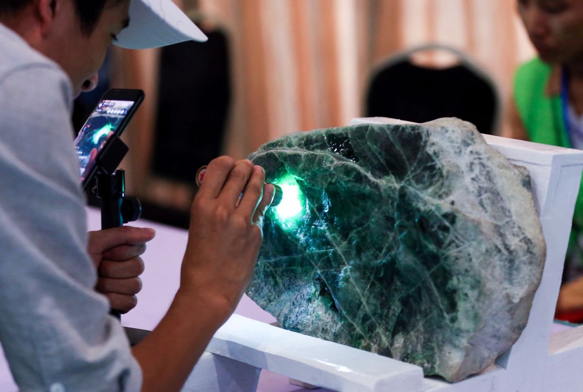 A buyer checks a jade stone before the auction during the annual Myanmar Jade, Gems and Pearl Emporium in Myanmar's capital of Naypyidaw on September 16, 2019. (Photo by Thet AUNG / AFP)