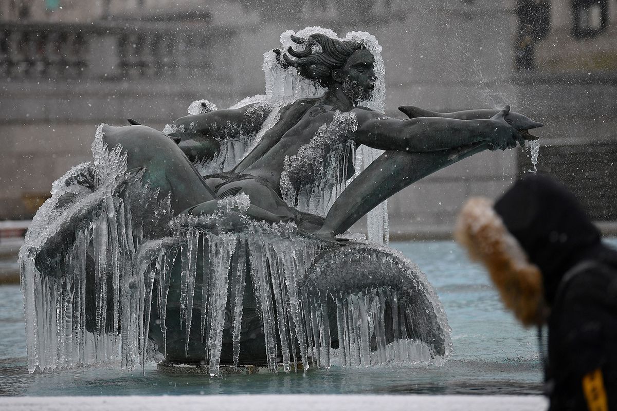 Ice is pictured on a mermaid statue in one of the fountains in Trafalgar Square in London on February 9, 2021. - Cold weather swept across northern Europe bring snow and ice. (Photo by JUSTIN TALLIS / AFP)
